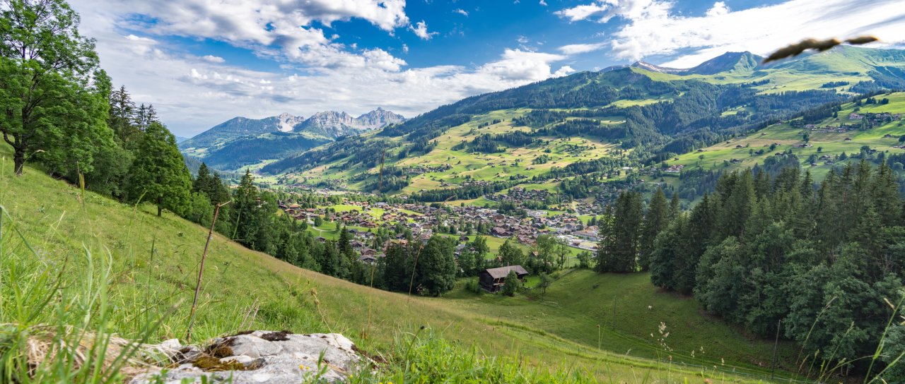 Eine Aussicht auf das Dorf Lenk mit den Spilgerten im Hintergrund bei sonnigem Wetter